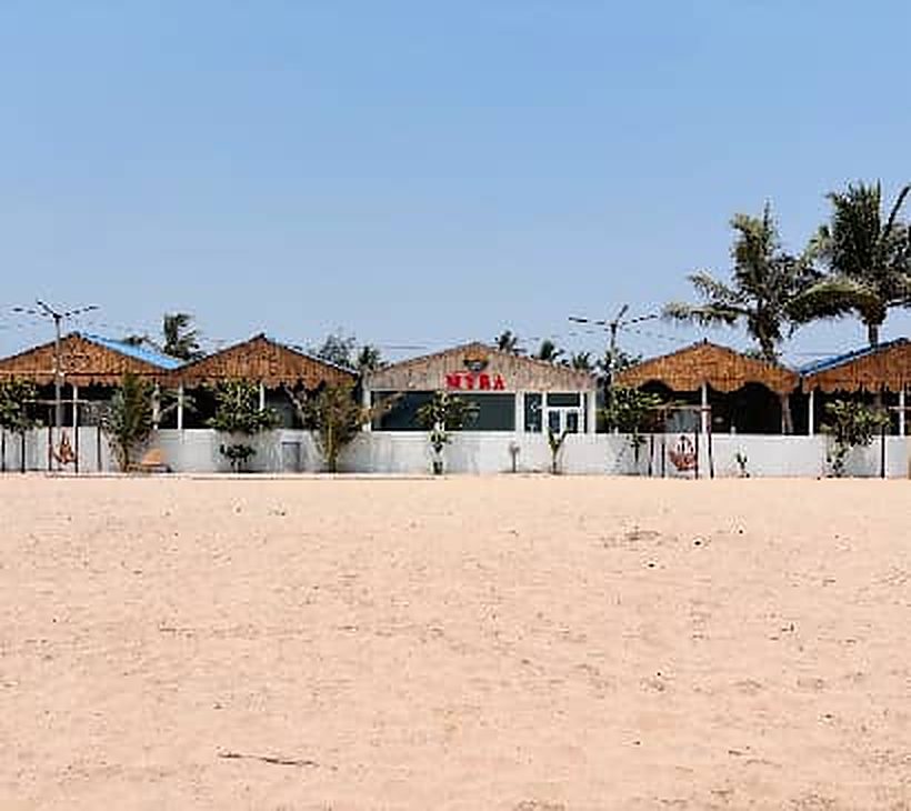 Thatched beach huts facing an empty stretch of sand