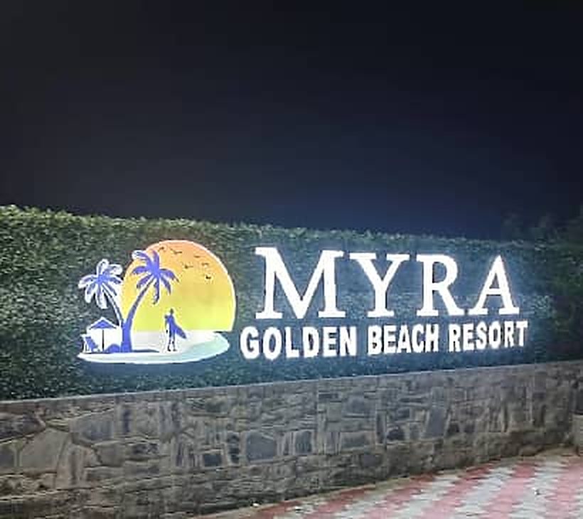 Illuminated Myra Golden Beach Resort sign at night